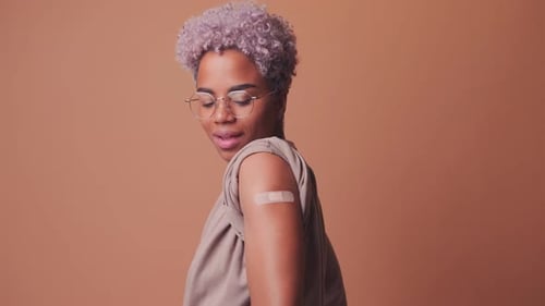Smiling Young Adult with Band-Aid on Upper Arm