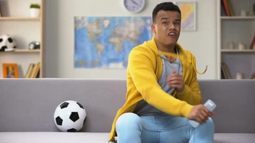 Young Adult Sits On A Couch With A Ball