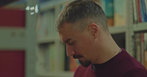 Porträt Grauhaariger Mann schaut vorsichtig in das Buch