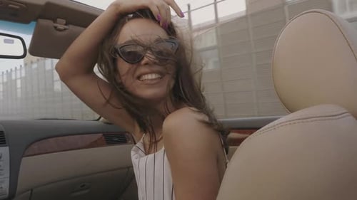Smiling Woman in Convertible on Sunny Day