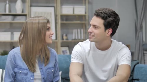 Young Couple Sitting and Talking on Blue Couch