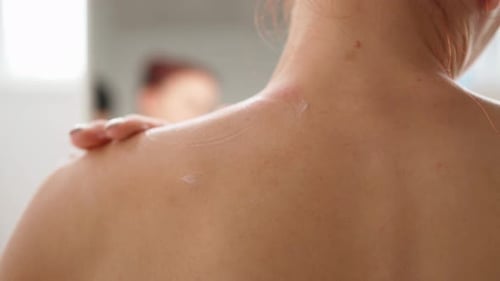 Woman Applying Moisturizer to Smooth Skin
