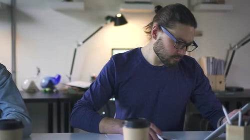 Young European Businessmen are Working with Devices at Table in White Office