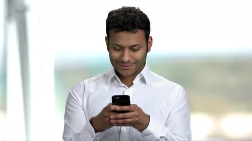 Indian Businessman Typing Message on Mobile Phone.