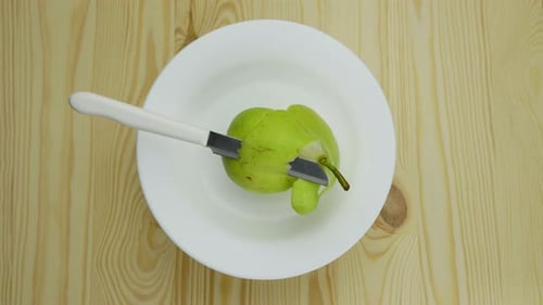 Pear peeling Stop Motion. A knife is peeling a green pear by itself.