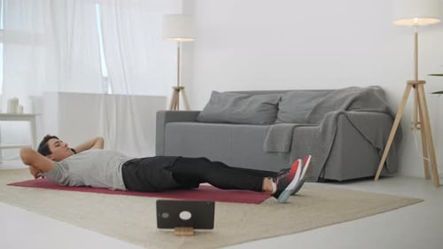 Adult Male Exercising at Home on Exercise Mat
