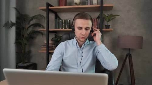 Caucasian Man, Call Center Agent in Headset Consult Business Client Online Using Laptop