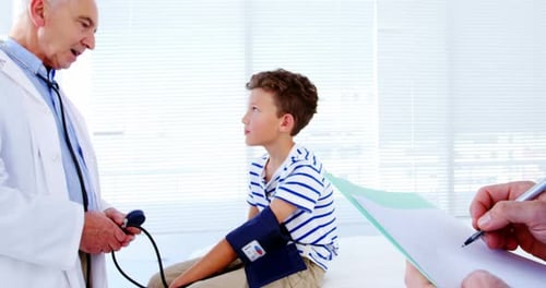 Doctor Checks Boy's Blood Pressure in Clinic