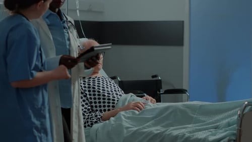 Personal médico multiétnico y paciente en la sala del hospital