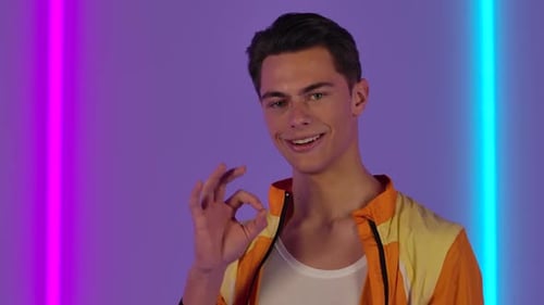 Smiling Young Adult Gives Okay Gesture