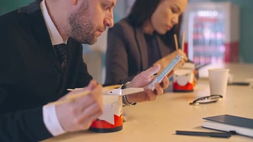 Business People Lunching at Table Looking at Phones