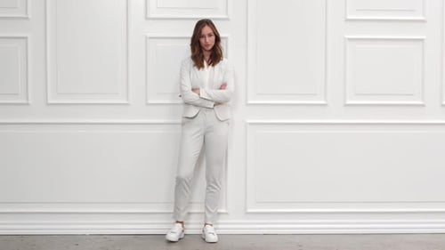 Woman Posing in Pale Gray Pantsuit and Sneakers