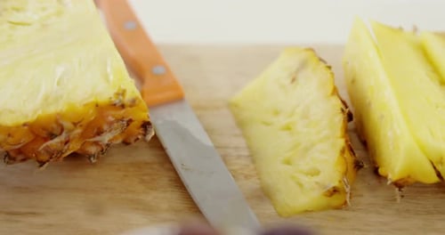 Sliced Pineapple With Knife On Cutting Board
