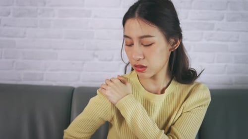 Young Woman Massaging Sore Neck and Shoulder