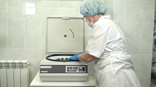 Medical Professional Using Centrifuge in Hospital Setting