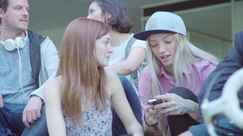 Friends Chatting with Smartphone in Urban Setting