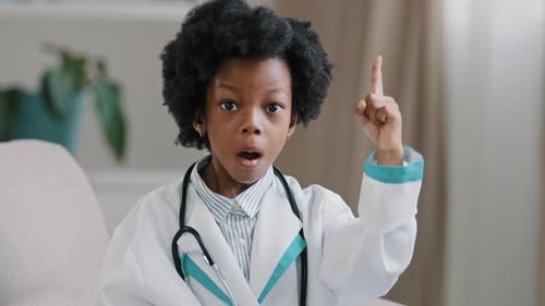 Child Dressed as Doctor Raising Finger Indoors