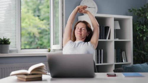 Woman Stretching at Her Desk at Home