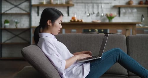 Young Woman Relaxing at Home with Laptop