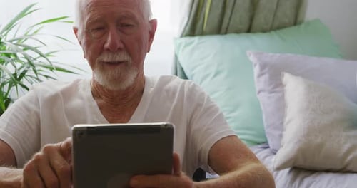 Elderly Man Using Digital Tablet in Home Setting
