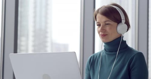 Femme d'affaires parlant joyeusement lors d'un appel vidéo en ligne en utilisant un ordinateur portable.