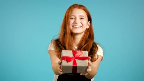 Smiling Woman Giving a Birthday Gift on Blue