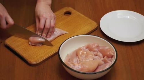 Mãos cortando carne fresca, cortando carne em uma tábua de cozinha, cortando carne crua