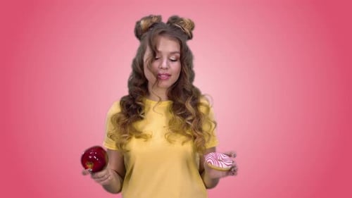 Hermosa joven con una camiseta amarilla hace una elección a favor de productos saludables y sonrisas
