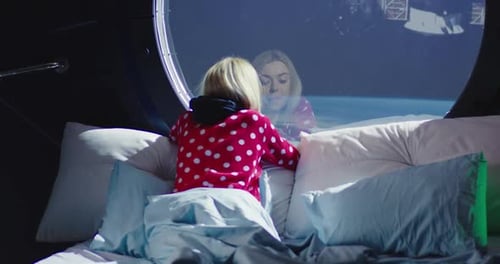 Femme regardant par la fenêtre du vaisseau spatial