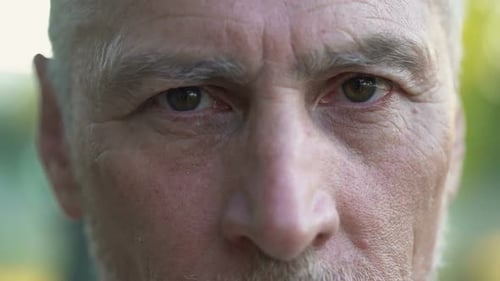Zerknitterter Rentner lächelt und schaut Verwandte mit Liebe an, Pflegeheim