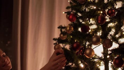 Family Decorating Christmas Tree with Ornaments and Star