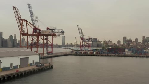 Fliegen in Richtung Industriekrane in Docks mit der Skyline von New York City im Hintergrund und Fluss
