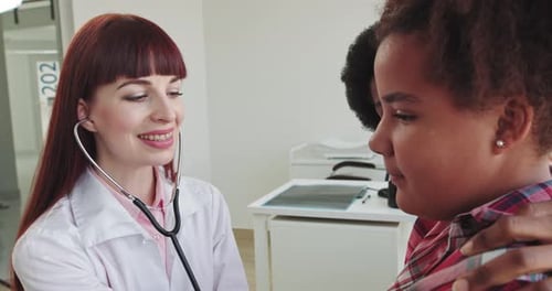 Doctor Examines Child Patient with Stethoscope in Office