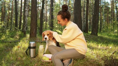 Happy Woman Petting Dog and Posing for Camera in Forest