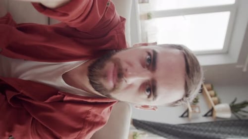 Smiling Man Talking Directly to the Camera Indoors