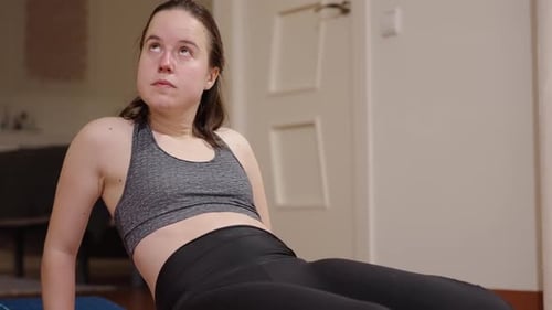 Woman exercising on floor in indoor home setting