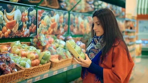 Happy Woman Grocery Shopping at the Supermarket