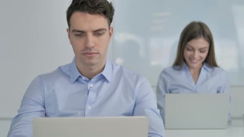 Young Businessman Working on Laptop in Office