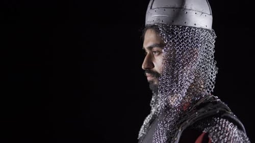Man Wearing Chainmail and Helmet Holding a Sword