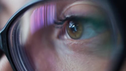 Eye and Glasses Reflecting Colorful Screen Close Up