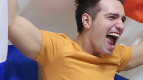 Enthusiastic Young Man Cheering with Arms Raised