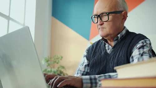 Senior Man Working at Laptop at Home