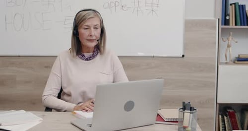 Teacher Leads Online Class with Headset and Laptop