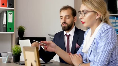 Business Professionals Discussing Details at an Office Desk
