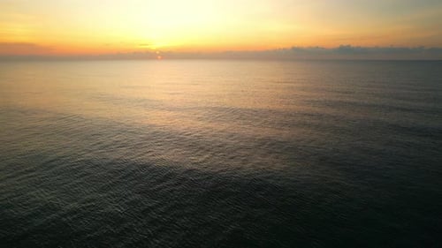 4K-Drohne fliegt über das Meer, Sonnenuntergang am Horizont