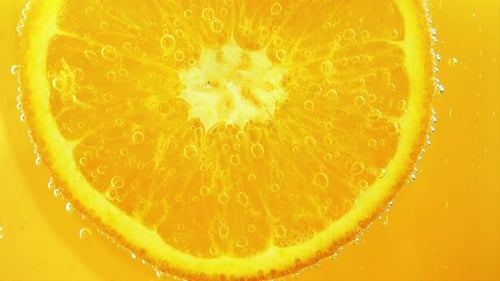 Luftblasen um eine Orangenscheibe.