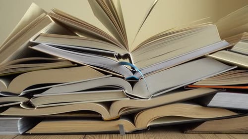 Stack of Open Books on a Wooden Table