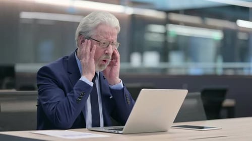 Senior Businessman Looking Stressed at His Laptop