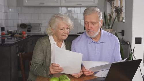 an Elderly Couple Discusses and Pays Bank Debts Keeps Accounts Does Paperwork Plans a Budget