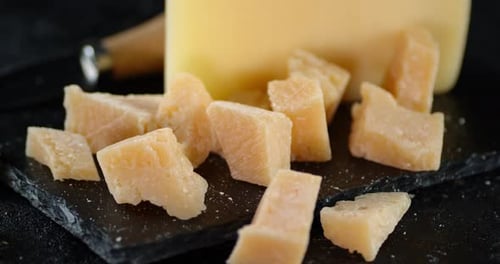 Les morceaux de parmesan sur une planche en pierre tournent lentement